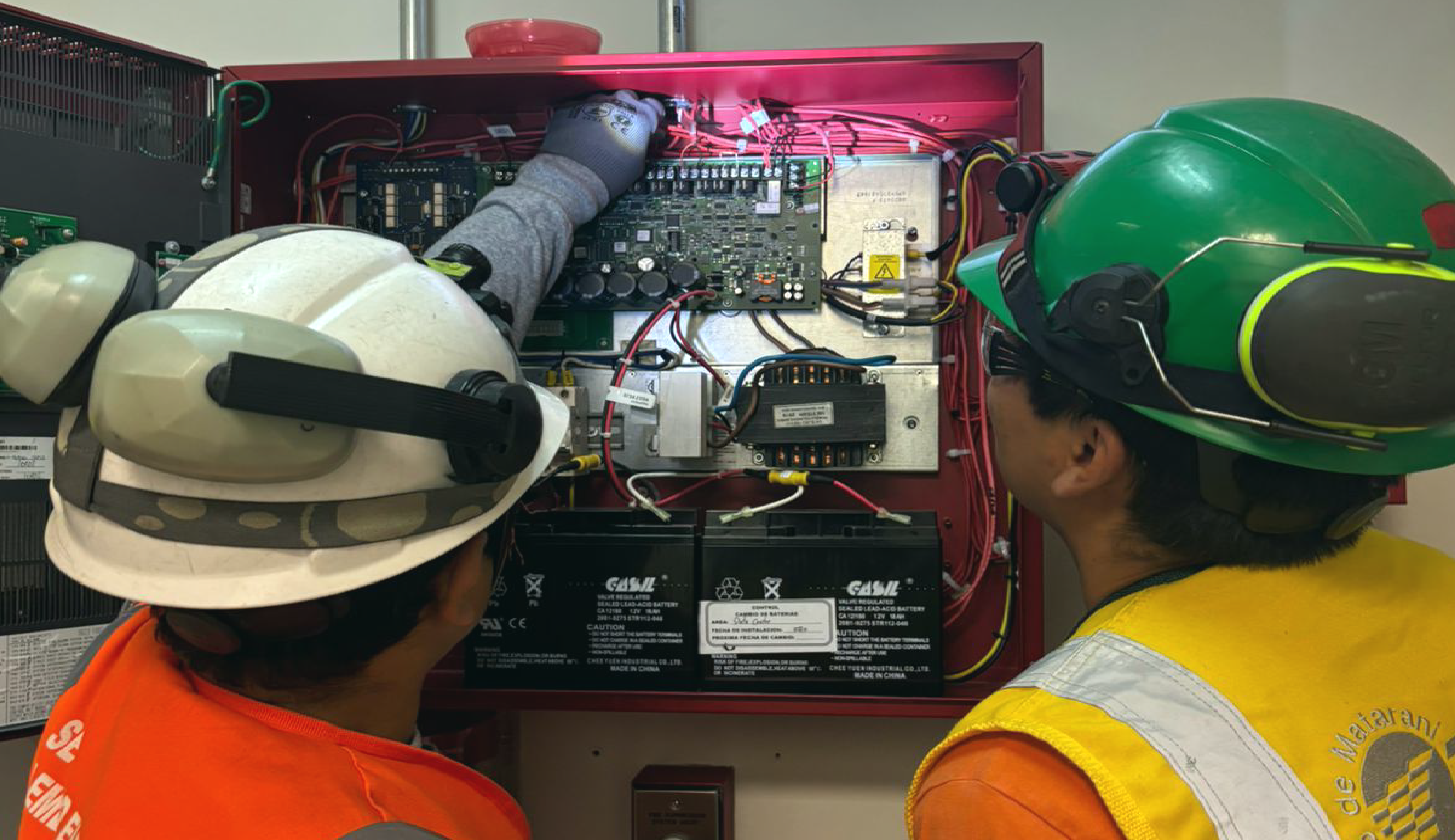 Equipo técnico de NEUTECH revisando un panel de alarma contra incendios